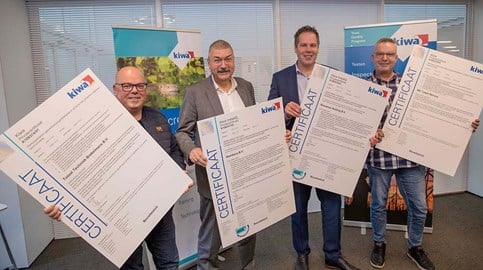Gecertificeerde Kiwa klanten op een rij terwijl ze uitvergrote certificaten vasthouden