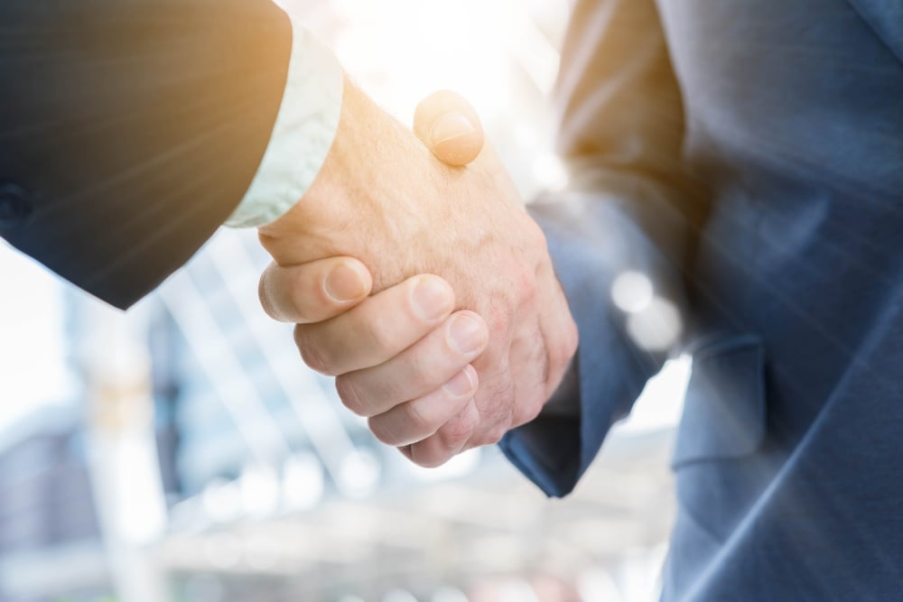 Primer plano de dos hombres dándose la mano.