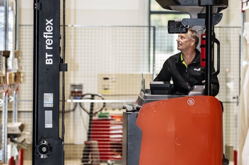 Besiktningsingenjör kontrollerar en truck på ett lager.